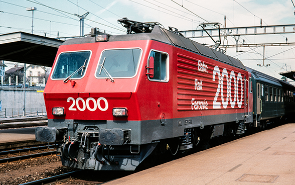 Locomotive des CFF frappée du slogan Bahn Rail Ferrovia 2000 en gare de Morges (VD)